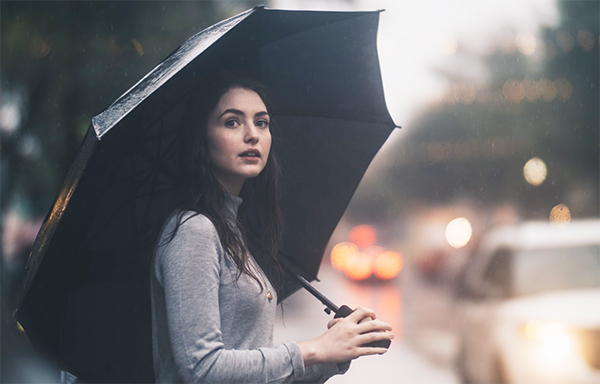 雨の中、傘をさしている女性