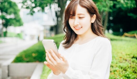 外でスマートフォンを見ている女性